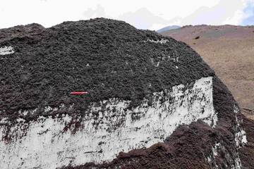 Nezpevěný sopečný materiál (tefra) současných erupcí Etny překrývající sněhové pole pod vrcholovými partiemi Etny. Foto: Lukáš Krmíček